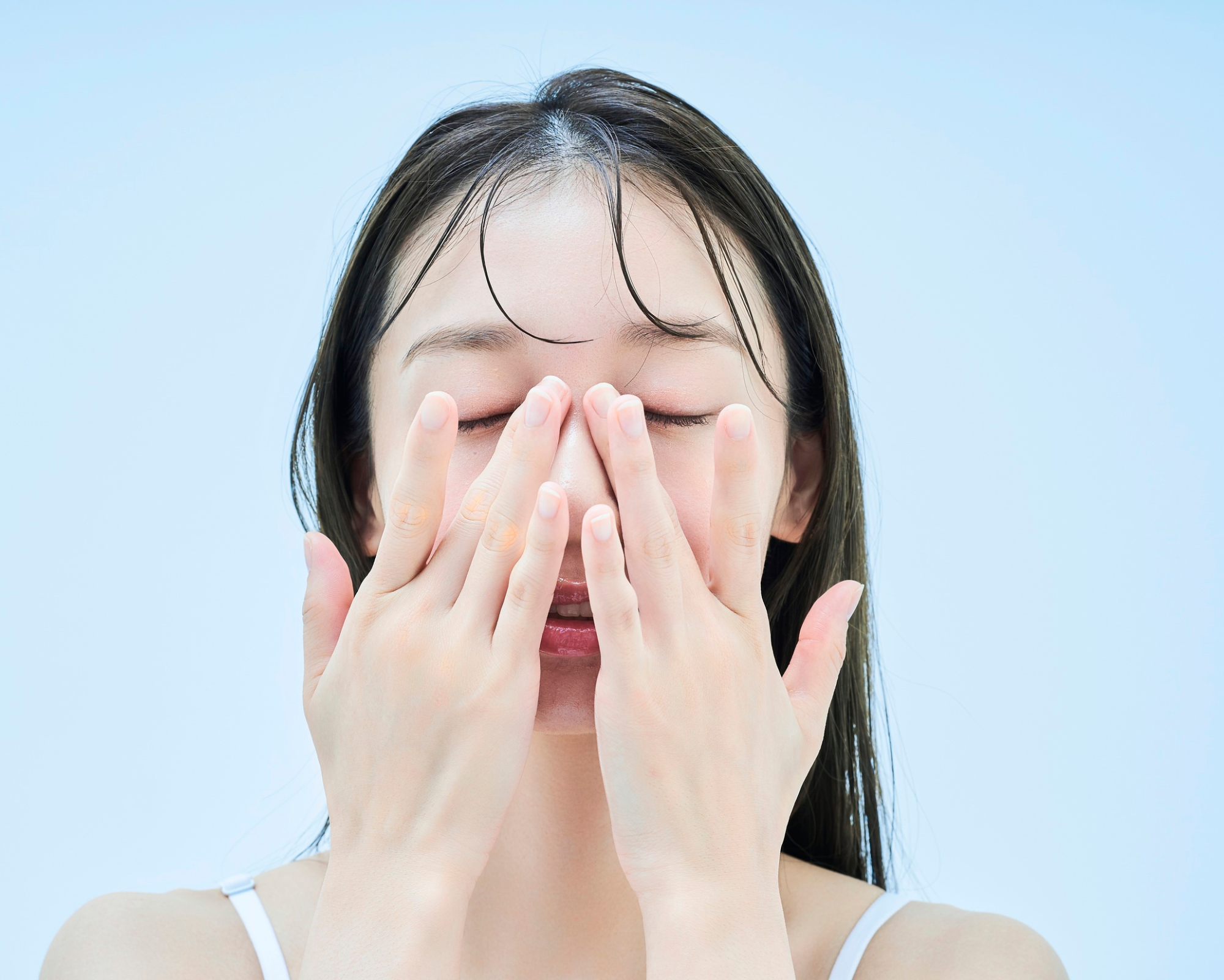 顔に化粧水をなじませる様子